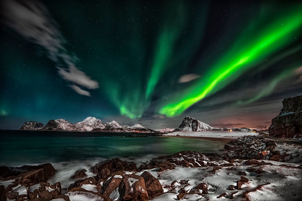 Captivating view of the Northern Lights over snow-covered Lofoten Islands at night.