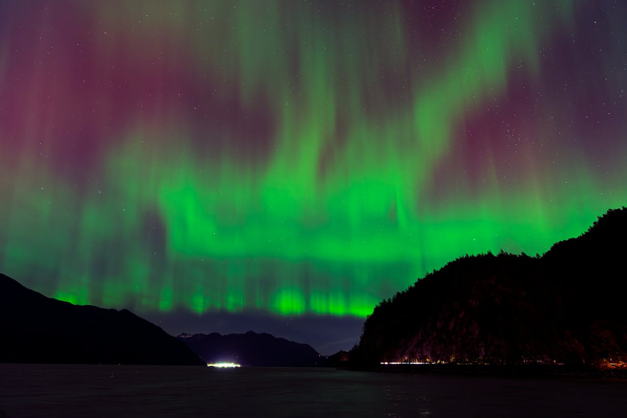 Breathtaking display of the aurora borealis illuminating the night sky over a serene fjord.