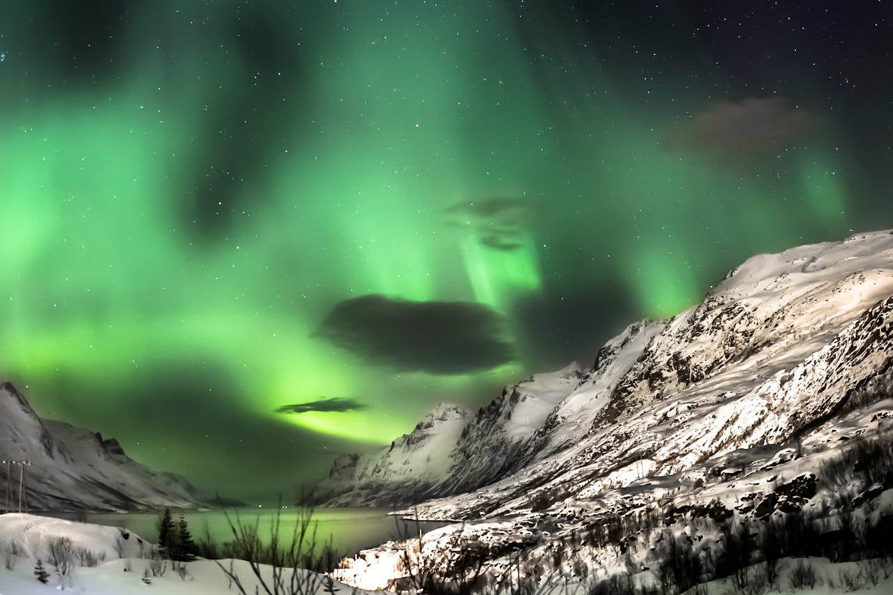 Breathtaking aurora borealis over snow-capped mountains near Oslo, capturing nature's winter magic.